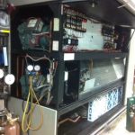 A large industrial furnace surrounded by various types of equipment, showcasing a complex manufacturing environment.